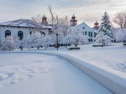 Looking down campus walkway towards College Hall, all blanketed in snow.